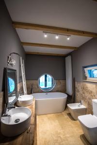 La salle de bains est pourvue de 2 lavabos, d'une baignoire et de 2 toilettes. dans l'établissement Guesthouse 340, à Roman