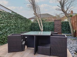 a patio with a table and wicker chairs at 19 Slinger Road in Cleveleys
