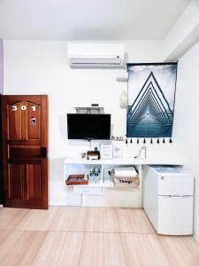 a living room with a tv and a desk at Zheng Yi Homestay in Taitung City
