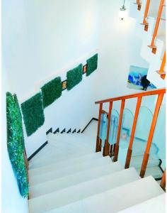 - un escalier dans une maison avec des murs blancs et des touches de vert dans l'établissement Aashiyana, à Nashik