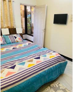 - une chambre avec 2 lits et une télévision murale dans l'établissement Aashiyana, à Nashik