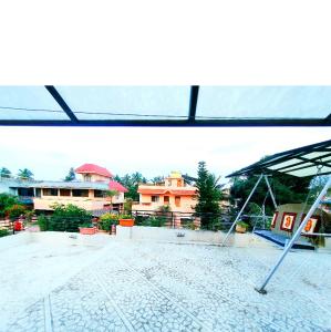 - une balançoire au milieu d'un patio avec des maisons dans l'établissement Aashiyana, à Nashik