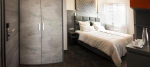a bedroom with a large bed and a closet at Hotel LifeStyle Mindelheim in Mindelheim
