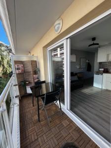 einen Balkon mit einem Tisch und ein Wohnzimmer in der Unterkunft Studio terrasse et parking privé in Nizza