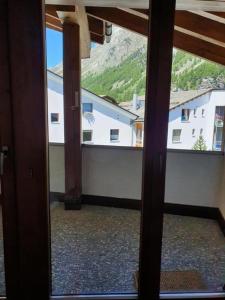 uma vista a partir de uma porta de vidro de um quarto com uma varanda em Chesa Foppas App Nr 7 em Sils Maria