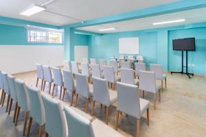 a conference room with a long table and white chairs at Hotel Tropical Park in Callao Salvaje +81 photos