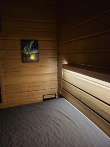 1 dormitorio con 1 cama en una habitación de madera en Tunturipöllö 4, en Ruka