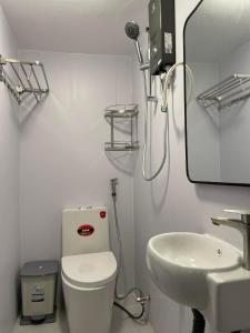 een badkamer met een toilet, een wastafel en een spiegel bij Alphabet Home Capsule in Ho Chi Minh-stad