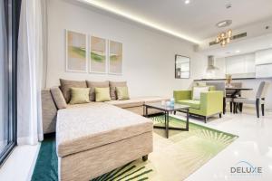 a living room with a couch and a table at Cordial 1BR at Celestia B Dubai South by Deluxe Holiday Homes in Dubai