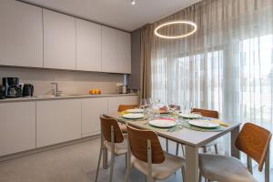 eine Küche und ein Esszimmer mit einem Tisch und Stühlen in der Unterkunft Luxury apartments Brijuni in Valbandon