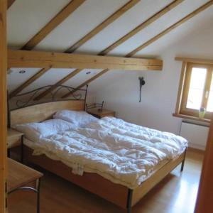 Cama grande en habitación con techo de madera en Haus 116A en Tarasp