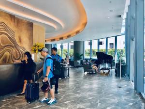 a group of people standing in a lobby with luggage at Panorama Nha Trang Condotel & Spa - 2 Nguyen Thi Minh Khai Nha Trang in Nha Trang