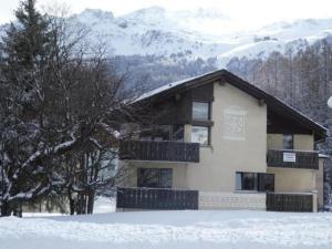 uma casa na neve com montanhas ao fundo em Chesa Margretta, 2 ZWG im 1 Obergeschoss em Sils Maria