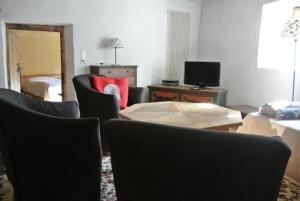 a living room with chairs and a table with a red pillow at Chesa Perini-Albertini in La Punt-Chamues-ch