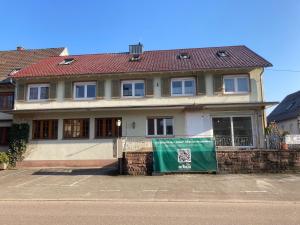 a house with a green banner in front of it at Ferienwohnung Smithson in Biberach