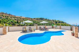 - une piscine avec des chaises et des parasols sur la terrasse dans l'établissement Villa Dos Hermanas, à Frigiliana