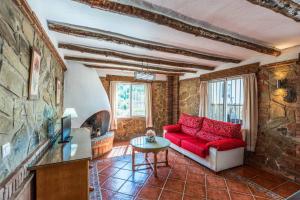 - un salon avec un canapé rouge et une télévision dans l'établissement Villa Dos Hermanas, à Frigiliana