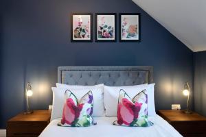 a bedroom with a bed with three pictures on the wall at Elliot Oliver - Loft Style 2 Bedroom Apartment With Parking In The Docks in Gloucester