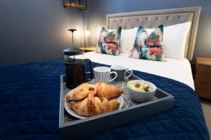 ein Tablett mit Brot und Obst auf dem Bett in der Unterkunft Elliot Oliver - Loft Style 2 Bedroom Apartment With Parking In The Docks in Gloucester