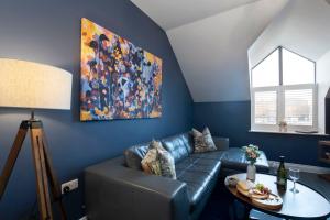 a living room with a couch and a painting on the wall at Elliot Oliver - Loft Style 2 Bedroom Apartment With Parking In The Docks in Gloucester