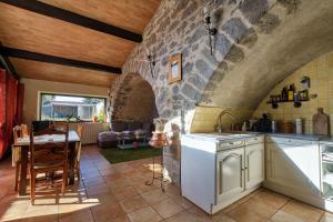 uma cozinha e sala de jantar com uma parede de pedra em JARDIN STE ANNE em Carcassonne