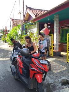 um grupo de pessoas sentadas numa scooter vermelha em Kubu Pilatus – Family House Lombok em Tjakranegara