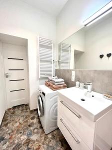 bagno bianco con lavatrice e lavandino di BoleslaviaApartments - Apartament Starówka 1 a Bolesławiec