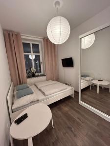 una camera con letto, tavolo e specchio di BoleslaviaApartments - Apartament Starówka 1 a Bolesławiec