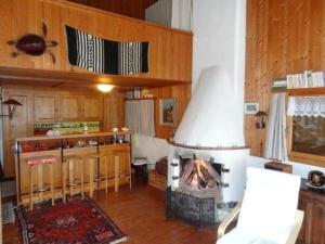 a kitchen with a fireplace in the middle of a room at Ferienhaus in Quinten-Au in Quinten