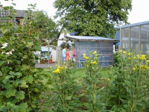 two children playing in a garden with a shed at Ferienhof Jens Ferienwohnung 4 in Kronsgaard
