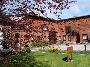 a brick building with a sign in front of it at Ferienhof Jens Ferienwohnung 4 in Kronsgaard