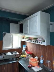a kitchen with white cabinets and a counter top at Lakenest overnight in Alleppey