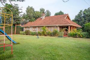 a house with a playground in the yard at United nations Bluezone stunning spacious cottage in Nairobi