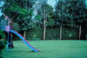 a playground with a slide in a park at United nations Bluezone stunning spacious cottage in Nairobi