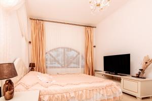 a bedroom with a bed and a flat screen tv at The Golden Nest - luxury apartment in Pamporovo