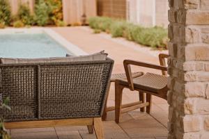 a wicker chair sitting next to a swimming pool at Vila Natura IV in Opatija