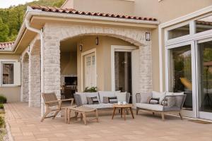 an outdoor patio with chairs and a table at Vila Natura IV in Opatija