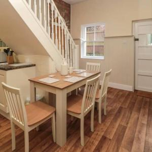 a dining room with a table and chairs and a staircase at Beautiful Countryside Cottage Alnwick in Alnwick