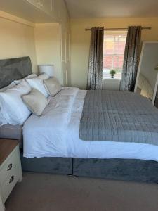 - une chambre avec un grand lit blanc et une fenêtre dans l'établissement Beautiful Countryside Cottage Alnwick, à Alnwick