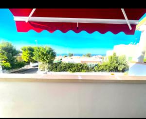 a window with a red umbrella and a view of a street at Deluxe Suite Santa Maria al Bagno with private pool in Nardò