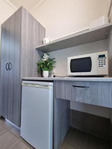 a kitchen with a microwave and a refrigerator at Y Motels Yarraman in Yarraman