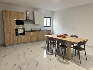 een keuken met een houten tafel en stoelen. bij Penthouse with 3 bedroom in Luqa