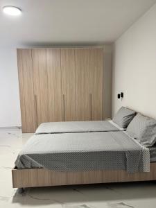 a bedroom with a large bed with a wooden cabinet at Penthouse with 3 bedroom in Luqa