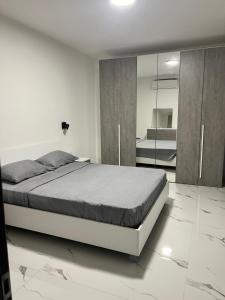 een slaapkamer met een groot bed en een spiegel bij Penthouse with 3 bedroom in Luqa