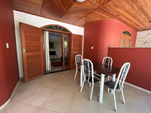 a dining room with a wooden table and chairs at Pousada Casa do Jova em Raposo RJ 