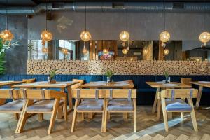 a restaurant with wooden tables and chairs and lights at Twins Hotel & Spa in Bukovel