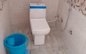 uma casa de banho com WC e um balde azul em Hotel Village Inn by StayApart em Barkot