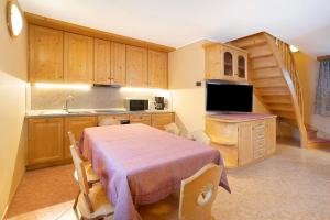 uma cozinha com uma mesa e um lavatório e uma cozinha com uma escada em Appartamento Gemma em Livigno