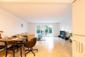 a dining room and living room with a table and chairs at Ground floor apartment - Peaceful living in the city of Zürich in Zürich