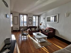 una sala de estar con un sofá y una mesa en Appart Gîte Les Oiseaux- face Loire Quai du Châtelet, en Orléans
